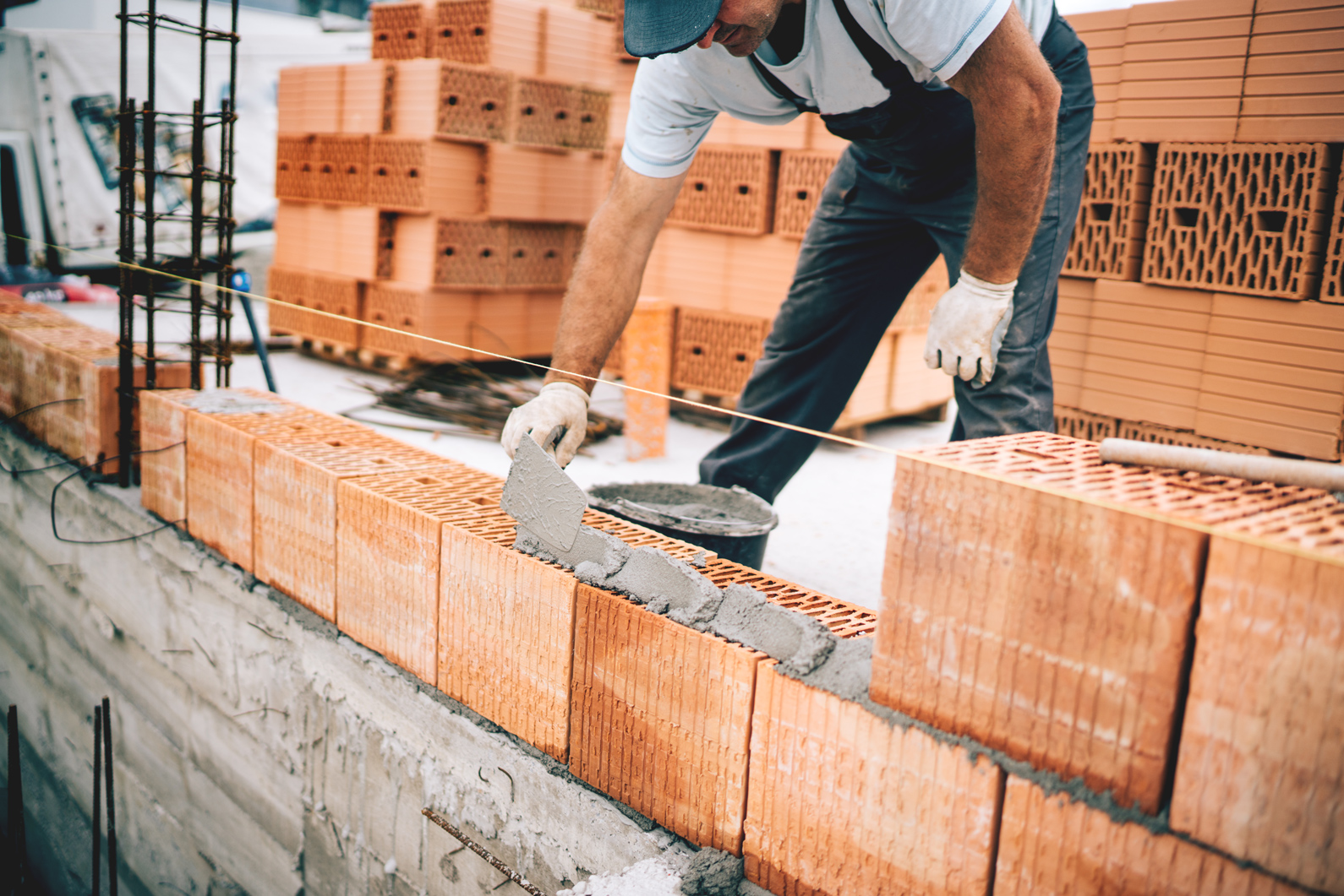 Un artisan maçon en train de monter un mur de parpaings